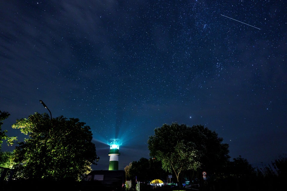 A shooting star passes over the Bülk lighthouse on the shore of the Baltic