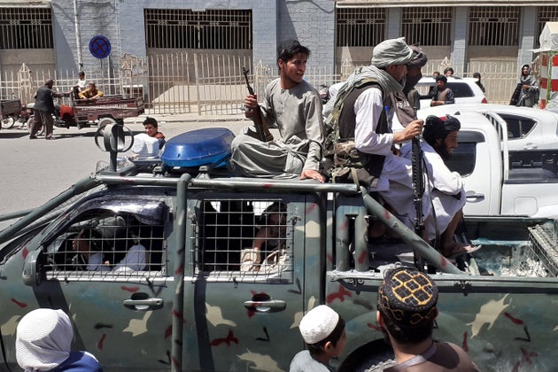 Taliban fighters are pictured in a vehicle of Afghan National Directorate of Security (NDS) on a street...