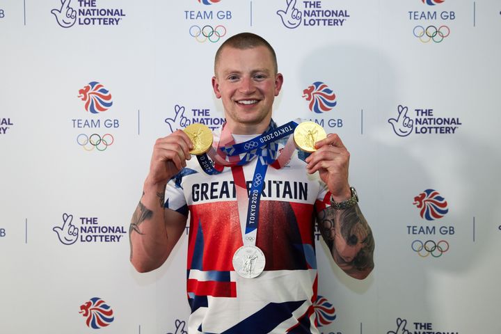 Adam Peaty poses with his medals from the Tokyo 2020 Olympics.