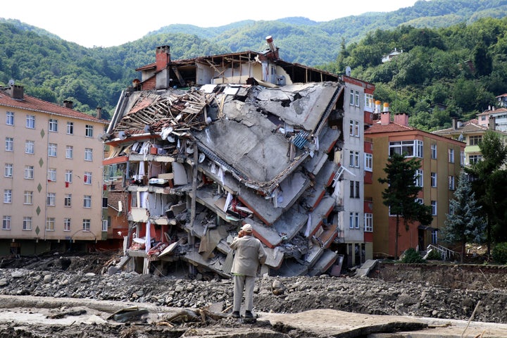 A man looks at destroyed building, in Bozkurt town of Kastamonu province, Turkey, Saturday, Aug. 14, 2021. 