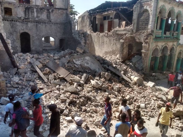  ハイチ南西部のジェレミーで、地震によって大きく損壊した建物にいる人々