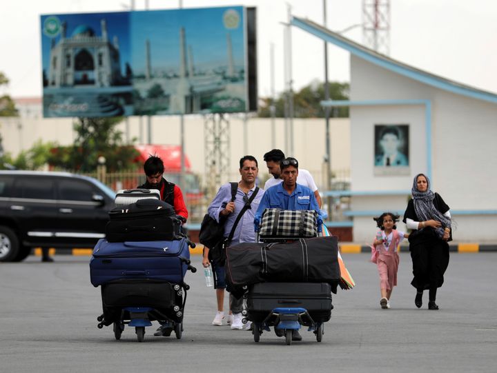 Passengers walk to the departures terminal of Hamid Karzai International Airport in Kabul, Afghanistan, Saturday, Aug. 14, 2021. (AP Photo/Rahmat Gul)