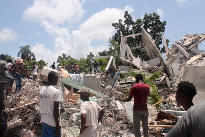 People search through the rubble of what used to be the Manguier Hotel after Saturday's earthquake.