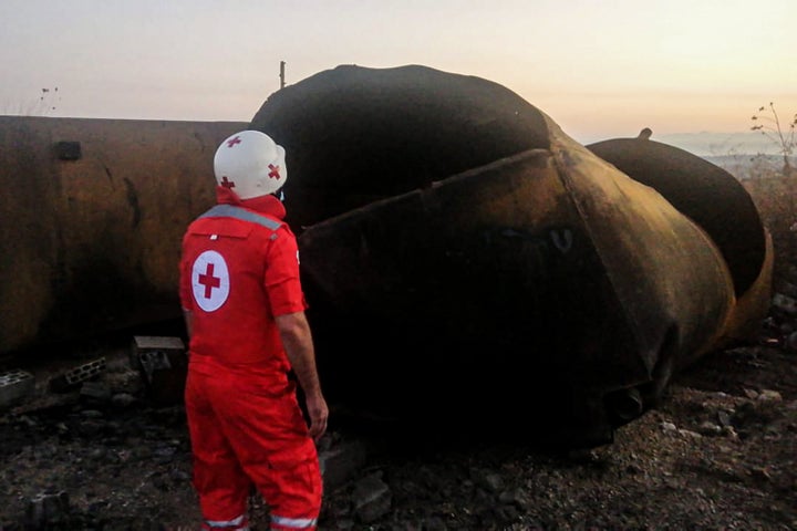 15 August 2021, Lebanon, Talil: A red cross volunteer stands near fuel tanks that exploded last night in the Lebanese norther