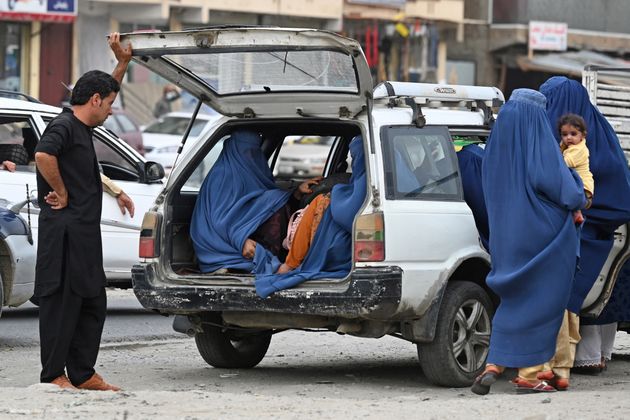 Des femmes portant une burqa entrent dans un taxi à Kaboul le 31 juillet 2021. (Photo by SAJJAD HUSSAIN / AFP)