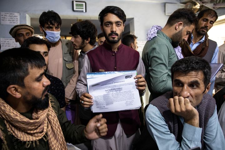 A man shows a certificate of appreciation from an American defense contractor while seeking help with his Special Immigrant Visa (SIV) application 