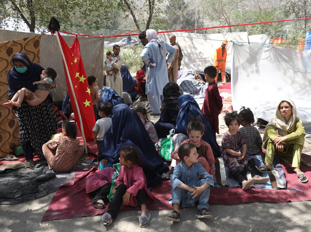Displaced families who fled from their homes take shelter in a public park in Kabul.