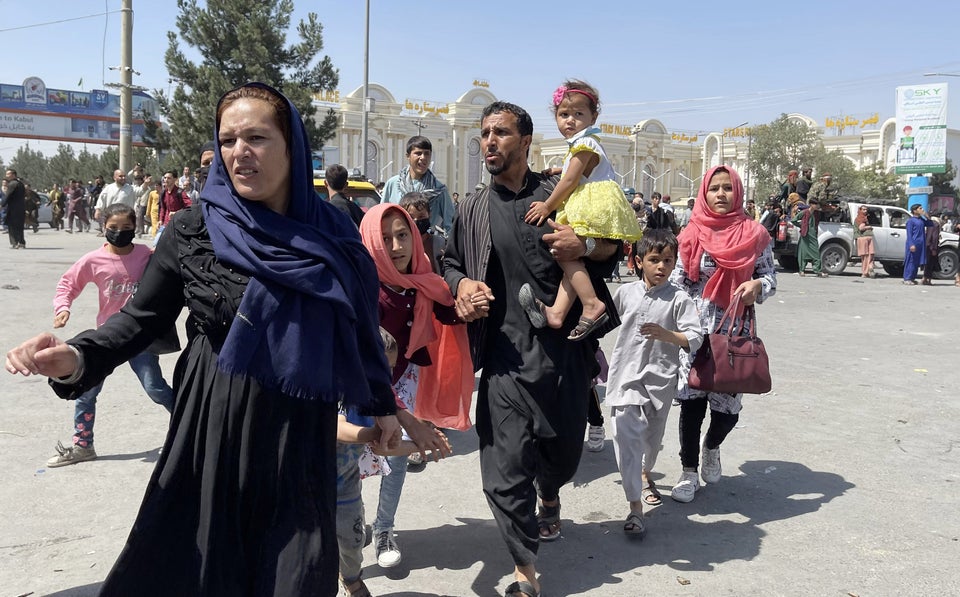 An Afghan family rushes to the airport as they flee the Afghan capital of