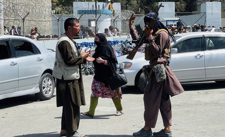 Taliban members are seen near Hamid Karzai International Airport as thousands of Afghans rush to Kabul