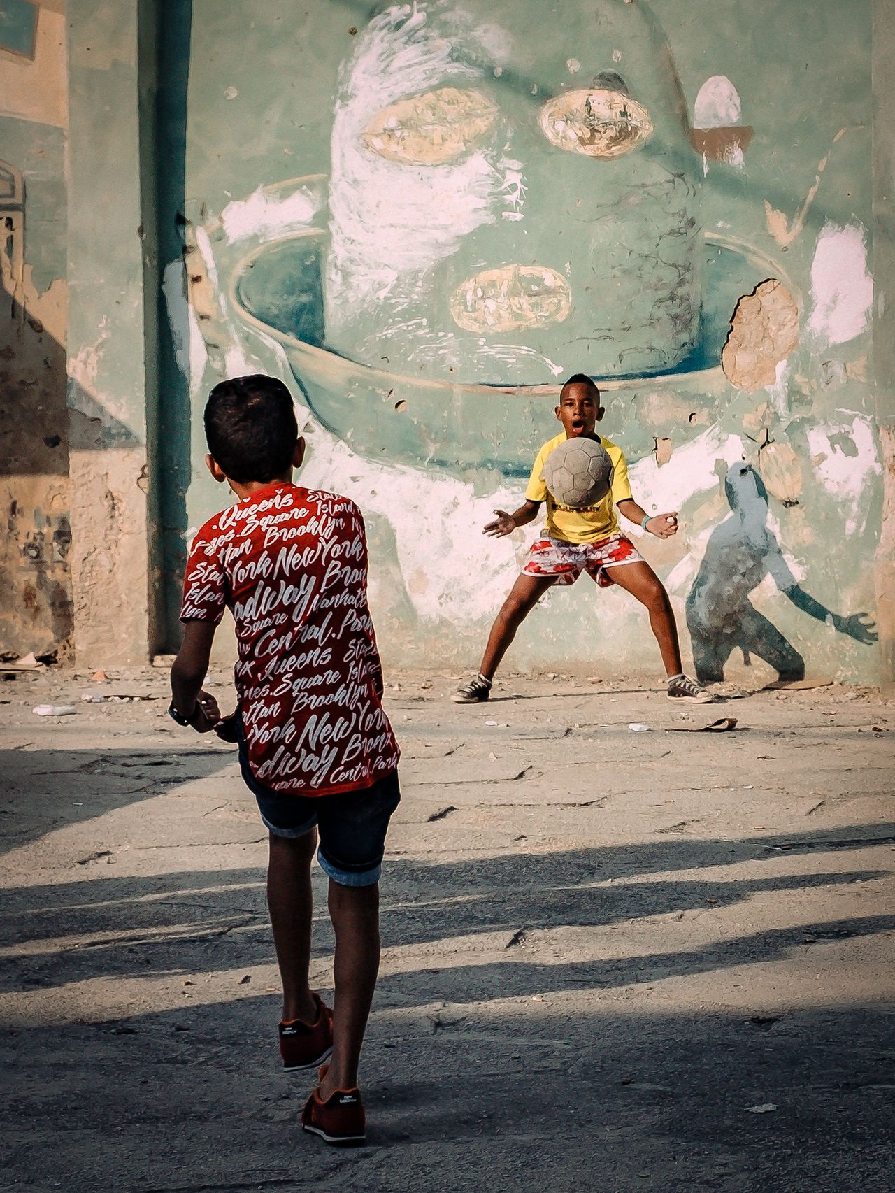 Sport category: Children play football in the street in Havana in this photograph