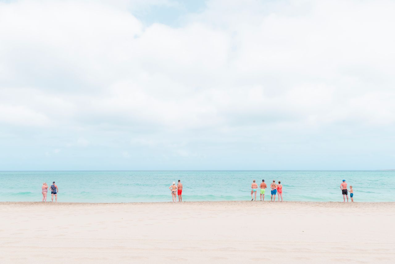 Travel and culture category: beachgoers gather by the shore to soak up the sunshine in the Cape Verde islands whilst maintaining social distancing