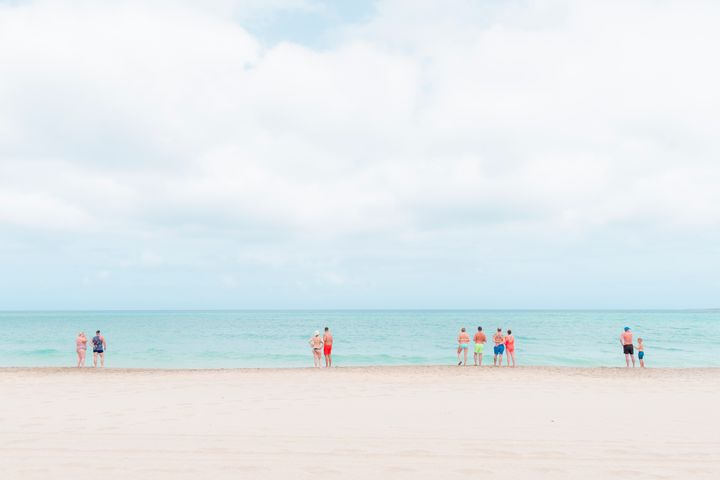 Travel and culture category: beachgoers gather by the shore to soak up the sunshine in the Cape Verde islands whilst maintaining social distancing