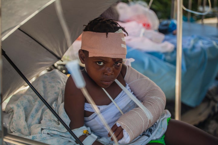 LES CAYES, HAITI - AUGUST 15: A boy is tended to outside Les Cayes General Hospital after a 7.2-magnitude earthquake struck Haiti on August 15, 2021 in Les Cayes, Haiti. Rescue workers have been working among destroyed homes since the quake struck on Saturday and so far there are 1,297 dead and 5.700 wounded. The epicenter was located about 100 miles west of the capital city Port-au-Prince. (Photo by Richard Pierrin/Getty Images)