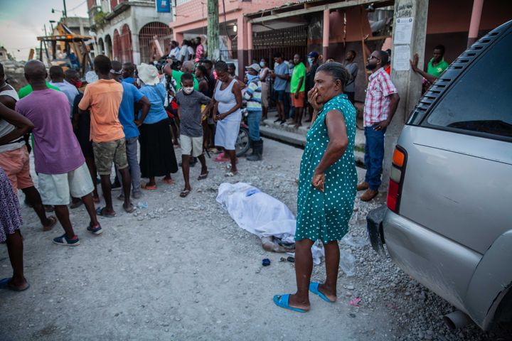 LES CAYES, HAITI - AUGUST 15: Haitians look over a casualty in the 7.2-magnitude earthquake on August 15, 2021 in Les Cayes, Haiti. Rescue workers have been working among destroyed homes since the quake struck on Saturday and so far there are 1,297 dead and 5.700 wounded. The epicenter was located about 100 miles west of the capital city Port-au-Prince. (Photo by Richard Pierrin/Getty Images)