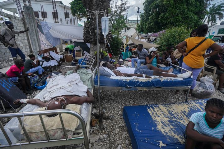 Injured people lie in beds outside the Immaculée Conception hospital in Les Cayes, Haiti, on Aug. 16, 2021.