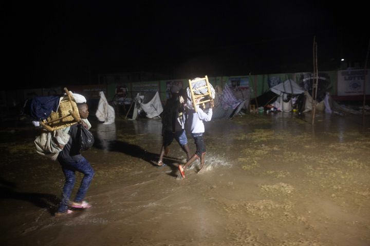 People leave as Tropical Storm Grace hits a refugee camp at a football field called Parc Lande de Gabion after a 7.2-magnitude earthquake struck Haiti on Aug. 16, 2021 in Les Cayes, Haiti.