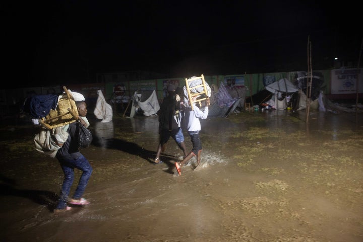 People leave as Tropical Storm Grace hits a refugee camp at a football field called Parc Lande de Gabion after a 7.2-magnitude earthquake struck Haiti on Aug. 16, 2021 in Les Cayes, Haiti.