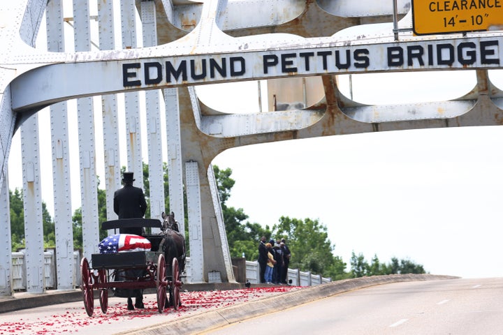 A horse-drawn carriage carrying the body of civil rights icon and former Rep. John Lewis (D-Ga.) crosses the Edmund Pettus Bridge as it prepares to pass members of his family on July 26, 2020, in Selma, Alabama.