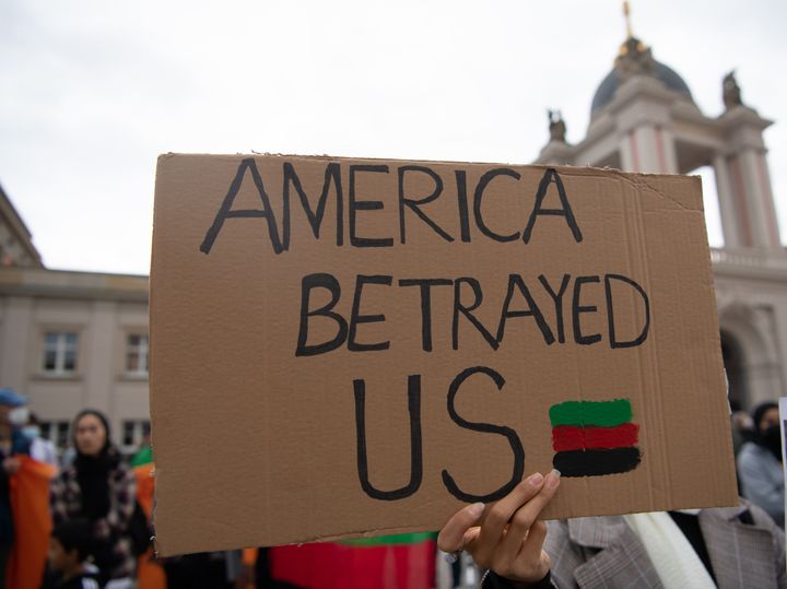 A protester at a rally in Germany on Tuesday holds up a sign that reads, "America Betrayed Us."