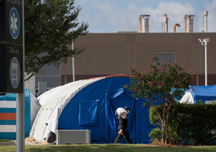 A construction crew sets up tents that hospital officials plan to use for an overflow of COVID-19 patients outside of Lyndon B. Johnson Hospital in Houston on Aug. 9.