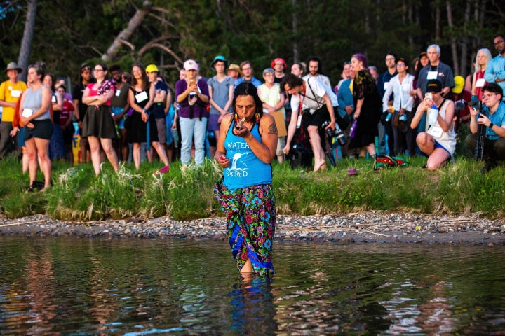 Environmental activist Winona LaDuke smokes tobacco at the conclusion of the Treaty People Gathering, where the faith leaders' welcome talk and sunset prayer circle are held in protest of the Line 3 pipeline at Northern Pines Camp in Park Rapids, Minnesota, on June 5, 2021.