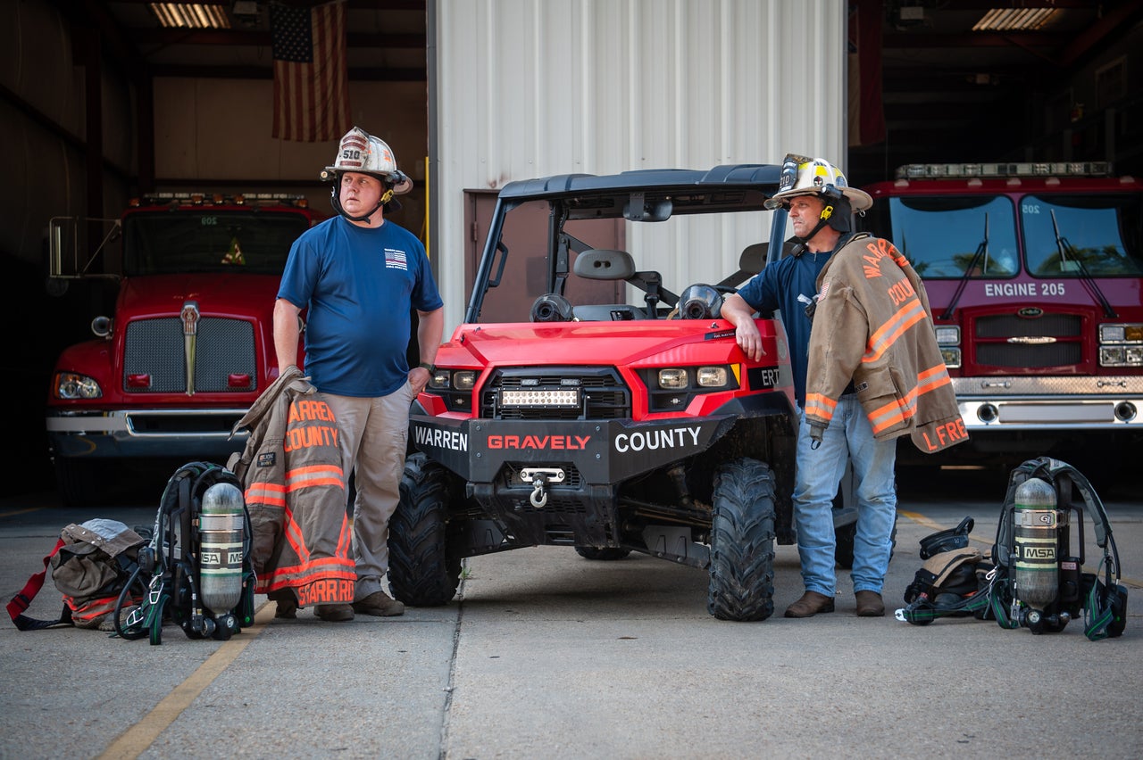 Warren County firefighters Shane Garrard (left) and Lamar Frederick in Vicksburg, Mississippi, in July. They're next to the utility task vehicle they used during the February 2020 gas leak in Satartia. <br><strong>Rory Doyle for HuffPost.</strong>