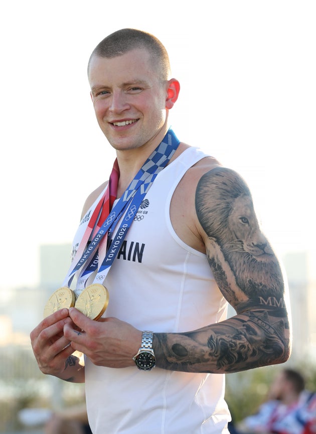 Adam Peaty poses with the two gold medals and the silver medal he won during the Tokyo 2020 Olympic
