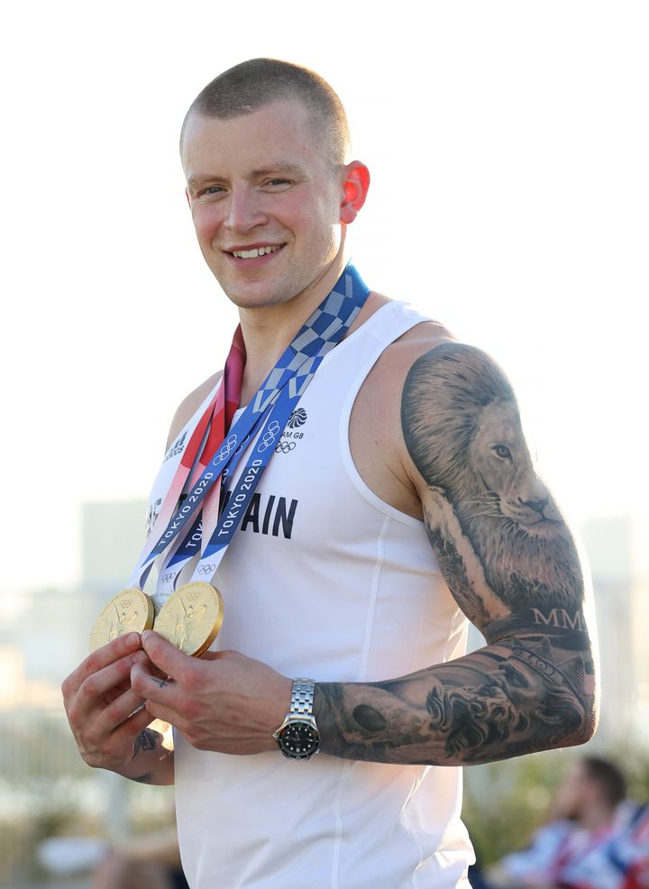 Adam Peaty poses with the two gold medals and the silver medal he won during the Tokyo 2020 Olympic Games.