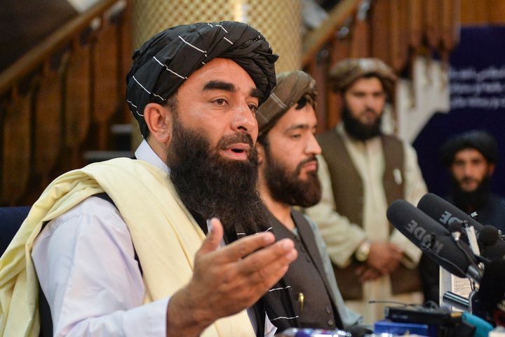 Taliban spokesperson Zabihullah Mujahid (L) gestures as he speaks during the first press conference in Kabul on August 17, 2021