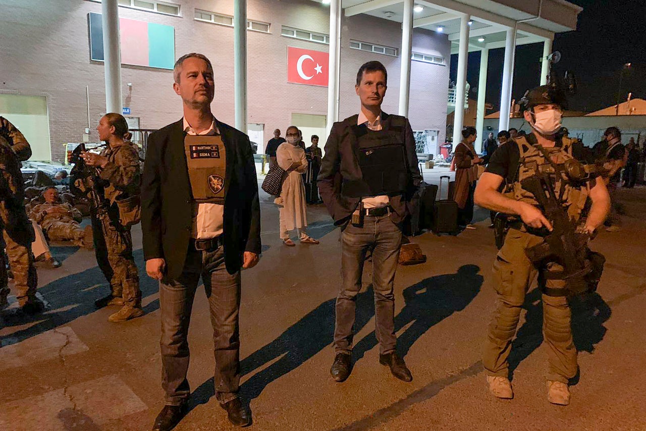 French ambassador to Afghanistan David Martinon waits with Afghan nationals in Kabul Airport