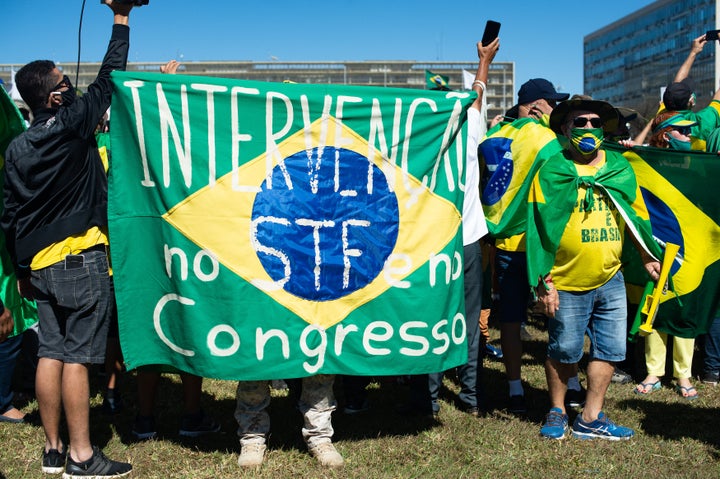 Supporters of Brazilian President Jair Bolsonaro hold a banner asking for military intervention during a protest amid the coronavirus (COVID-19) pandemic at the Esplanada dos Minsitérios on June 21, 2020, in Brasilia.