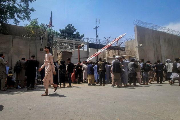 Des Afghans devant la porte principale de l'ambassade de France à Kaboul, en Afghanistan, le 17...
