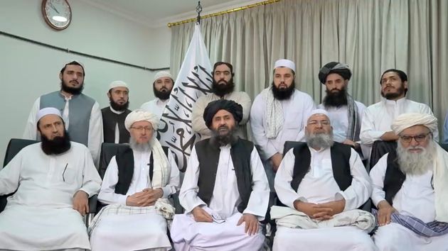 Le Mollah Baradar Akhund, assis avec un groupe d'homme dans le cadre d'une déclaration vidéo,...