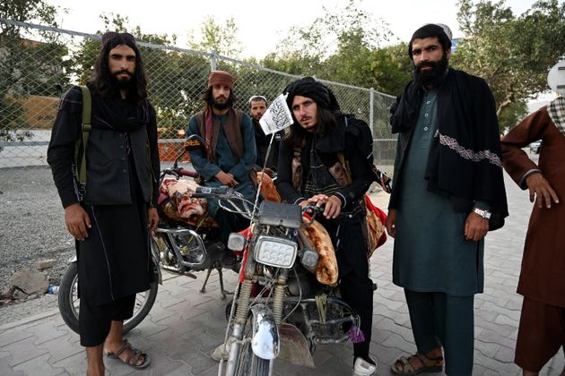 Taliban fighters stand along a road in Kabul on August 18, 2021, after the Taliban's military takeover...