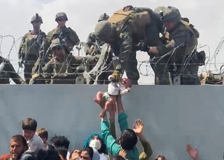 Δίνουν μωρό σε Αμερικανό στρατιώτη πάνω από το συρματόπλεγμα