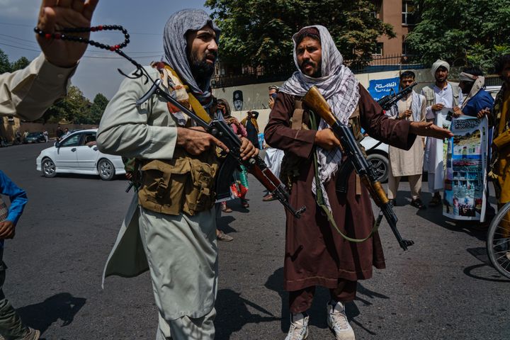 Taliban fighters mobilize to control a crowd
