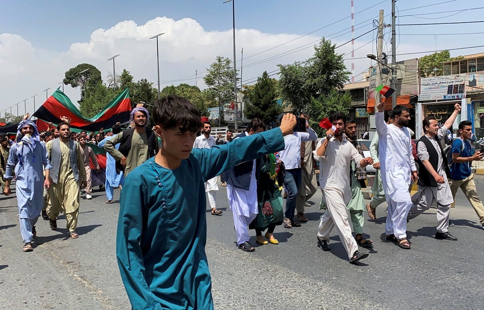 People carry the national flag at a protest held during the Afghan Independence Day in Kabul, Afghanistan...