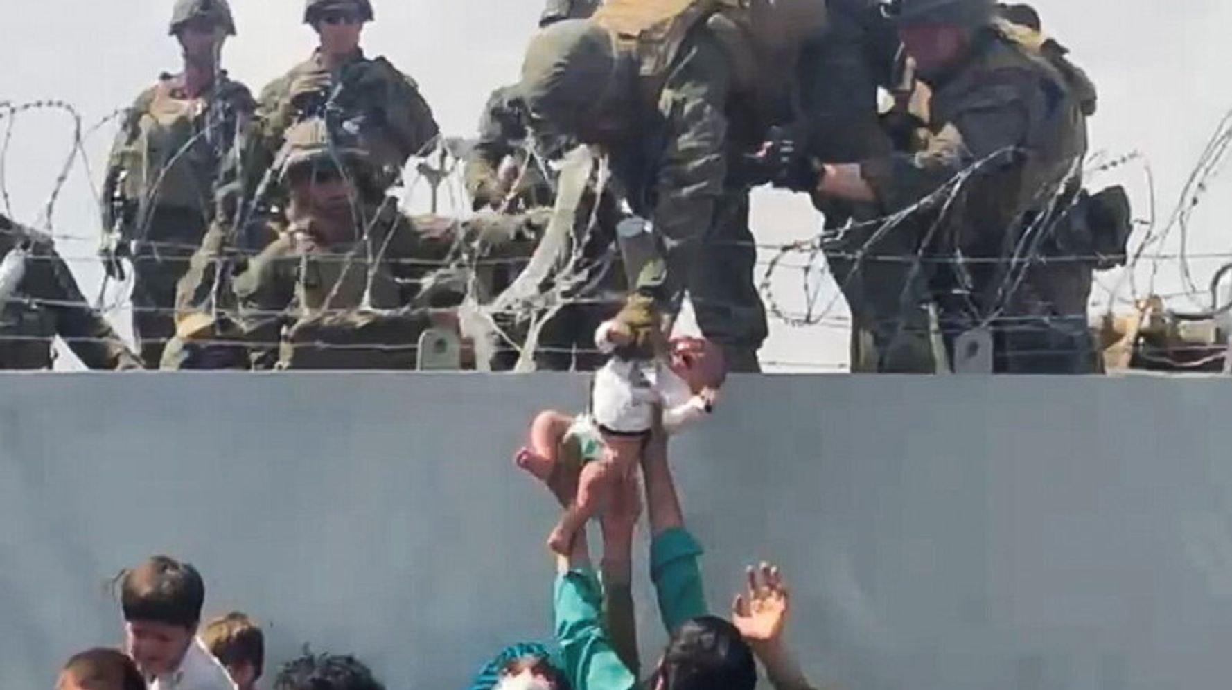 Afghans Photographed Handing Babies Over Barbed Wire To Soldiers At Airport