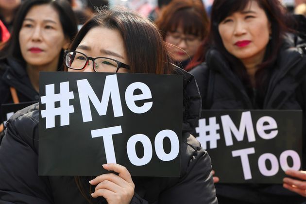韓国ソウルで開かれた国際女性デーの抗議デモで、#MeTooムーブメントのカードを掲げる人々（2018年3月8日）
