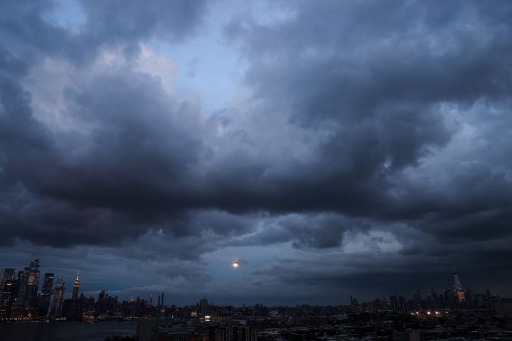 Huge clouds are seen as the full moon rises over Manhattan on August 20, 2021.