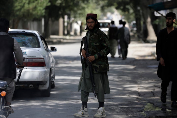 A Taliban fighter stands guard at a checkpoint in the Wazir Akbar Khan neighborhood in the city of Kabul on Sunday.