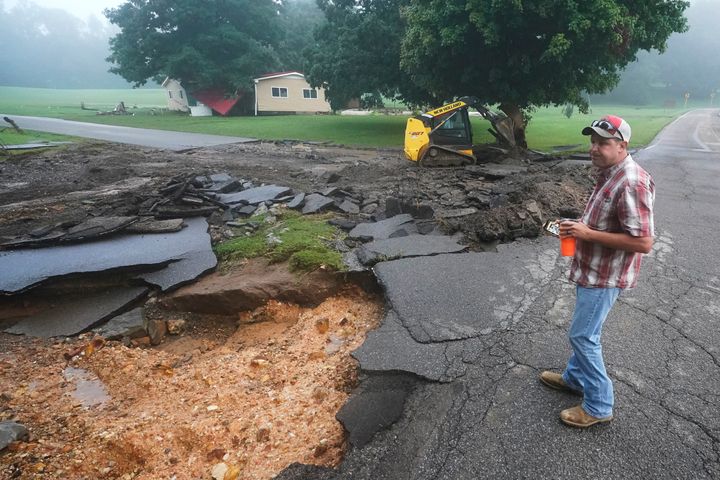 Michael Pate watches as a road is repaired Sunday, Aug. 22, 2021, in McEwen, Tenn. Pate repaired the road Saturday after heavy rain washed part of it away, but the road was damaged again when more rain fell Saturday night. (AP Photo/Mark Humphrey)