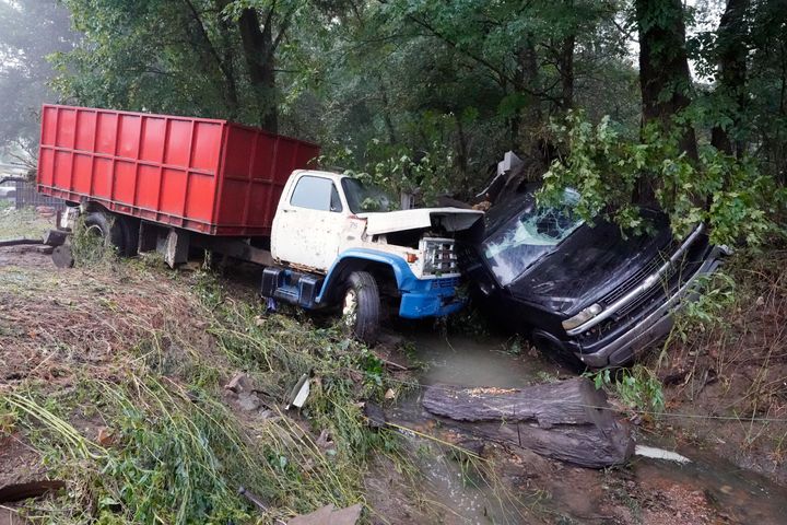 A truck and a car sit in a creek on Sunday, Aug. 22, 2021, after they were washed away the day before in McEwen, Tenn. (AP Photo/Mark Humphrey)
