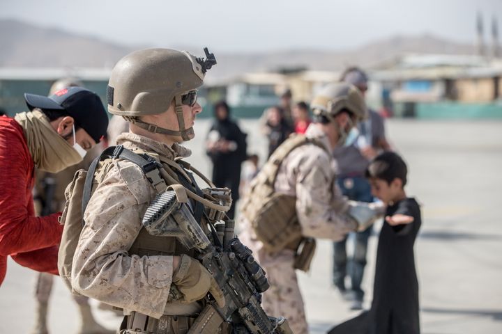 A U.S. Marine provides assistance during an evacuation at Hamid Karzai International Airport, Kabul, Afghanistan, August 21, 2021.