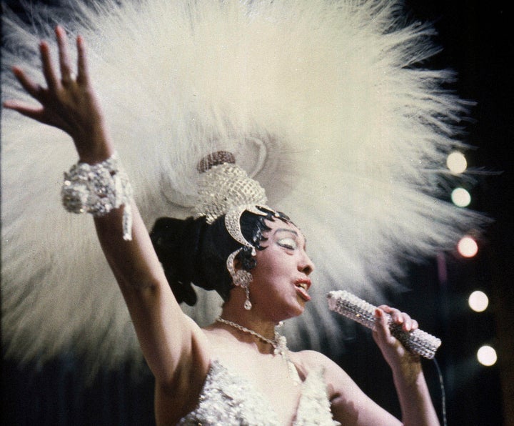 Josephine Baker holds a rhinestone-studded microphone as she performs during her show "Paris, mes Amours" at the Olympia Musi