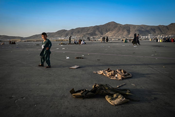 Un niño afgano camina junto a uniformes del ejército local, cerca del aeropuerto de Kabul, el pasado 16 de agosto.