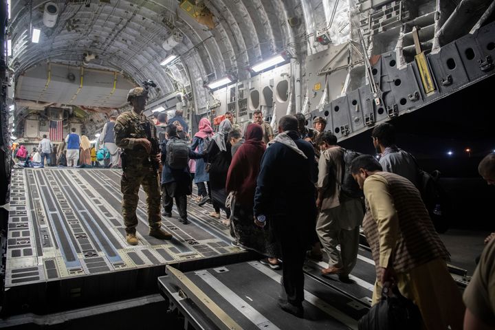 In this Aug. 22, 2021, photo provided by the U.S. Air Force, Afghan passengers board a U.S. Air Force C-17 Globemaster III du