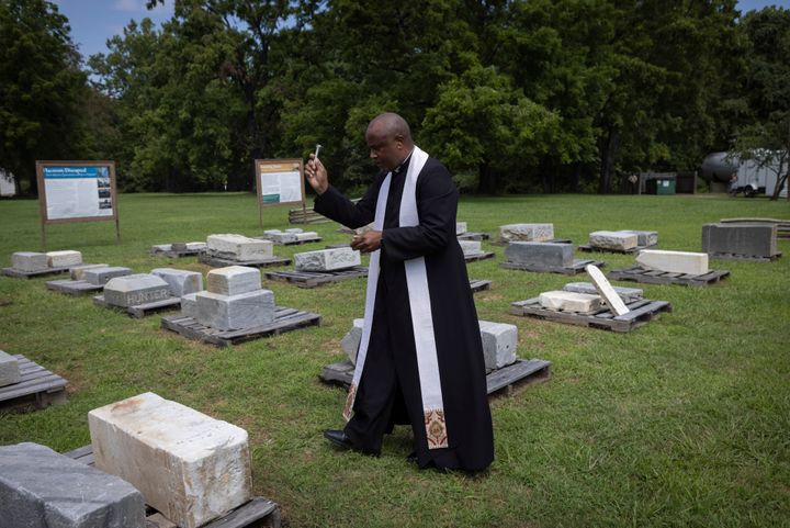 Rev. Lee Gandiya of St. Pauls Episcopal Church blesses gravestones during a ceremonial transfer on Monday at Caledon State Park in King George, Va.