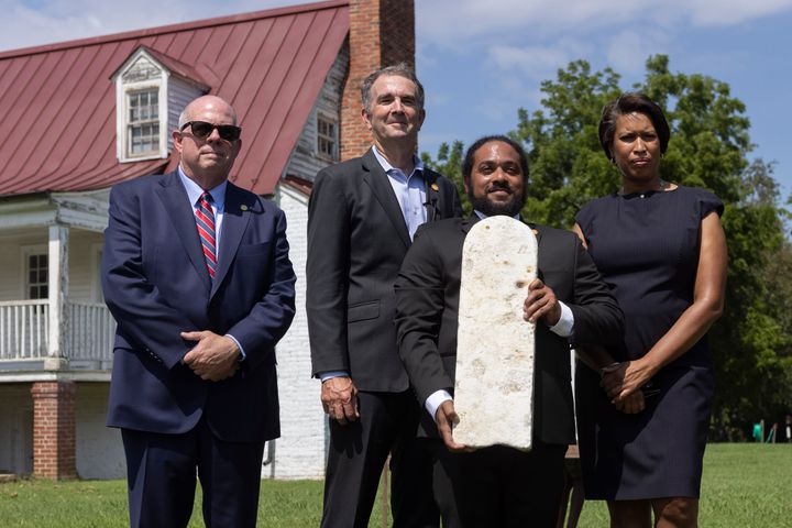 Nathan Burrell, with the Virginia Department of Conservation and Recreation, holds a grave marker and poses with, from left, 