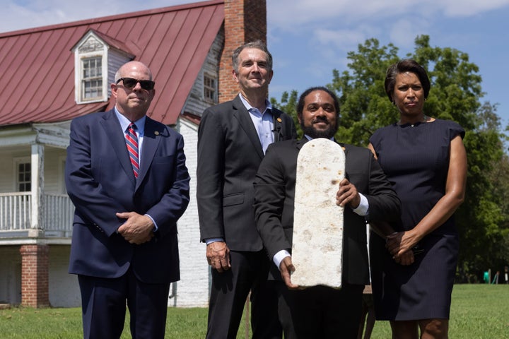 Nathan Burrell, with the Virginia Department of Conservation and Recreation, holds a grave marker and poses with, from left, 